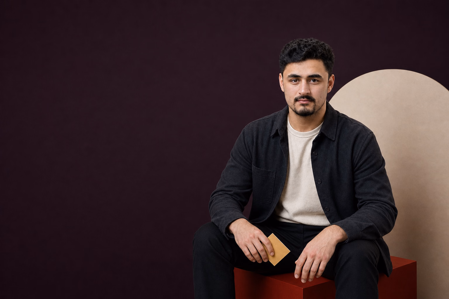 Anas seated in a tactile creative set with warm paper shapes
